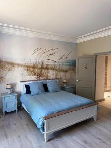 1 dormitorio con 1 cama con una pintura en la pared en La Maison Florence, en Mont-de-Marsan