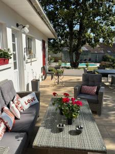 un patio con sofá y una mesa con flores en La Maison Florence, en Mont-de-Marsan
