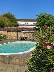 - une piscine avec une terrasse en bois à côté d'un bâtiment dans l'établissement La Maison Florence, à Mont-de-Marsan