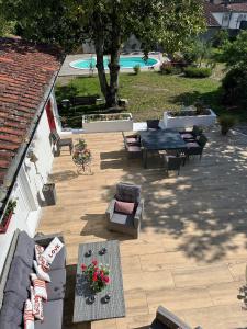 un patio con sofás, mesas y una piscina en La Maison Florence, en Mont-de-Marsan