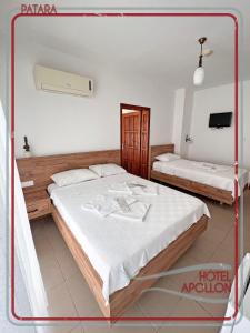 een slaapkamer met 2 bedden en een tv. bij Apollon Hotel in Patara
