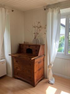 a room with a wooden dresser and a window at La Lanterne in Sierre