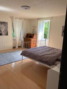 a bedroom with a bed and a desk and a window at La Lanterne in Sierre