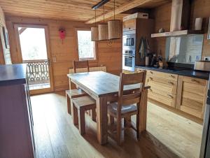 cocina con mesa de madera y sillas en Bas de chalet au coeur des Aravis, entre lac et montagne, en Saint-Jean-de-Sixt