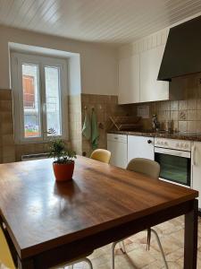 una cocina con una mesa de madera con una maceta. en La Lanterne, en Sierre