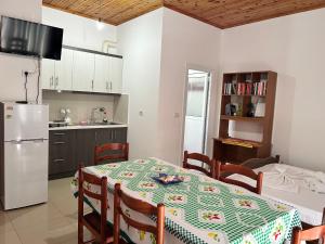 Il comprend une cuisine et une salle à manger avec une table et un réfrigérateur. dans l'établissement Guesthouse Dollomaja Ksamil, à Ksamil