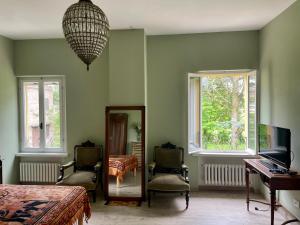GualdoにあるA Casa di Maicaの椅子2脚、鏡、窓が備わる客室です。