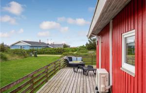 a red house with a deck with a bench at Stunning Home In Harbore With House A Panoramic View in Harboør