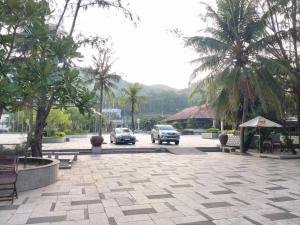 ein Parkplatz mit geparkten Autos und Palmen in der Unterkunft Lavender Sa Huỳnh Hotel Quốc Lộ 1A in La Vân (2)
