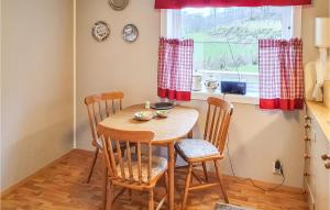 a table and chairs in a kitchen with a window at 3 Bedroom Awesome Home In Skjold in Skjold