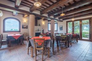 a restaurant with tables and chairs and a fireplace at Collina dei Poeti in Santarcangelo di Romagna