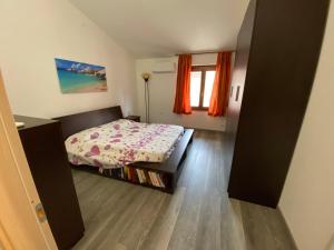 a small bedroom with a bed and a window at Il Nido in Gonnesa