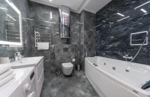 a black and white bathroom with a tub and a sink at Luxury Apartments Arena Guliver in Kyiv