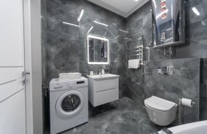 a bathroom with a washing machine and a sink at Luxury Apartments Arena Guliver in Kyiv