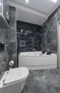 a bathroom with a tub and a toilet and a sink at Luxury Apartments Arena Guliver in Kyiv