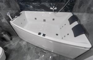 a white bath tub in a bathroom with a toilet at Luxury Apartments Arena Guliver in Kyiv
