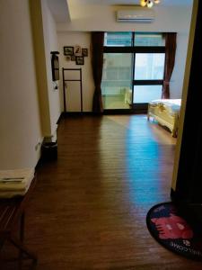 a room with a hard wood floor and a bed at 歐巴虎將去旅行오빠 & フーちゃん系列一招待所週年感恩活動 近車站慈濟 後站莊太太民宿 in Hualien City