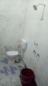 a bathroom with a toilet with blueprints on the floor at SPOT ON Green Hotel in Meerut