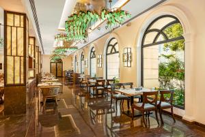 a restaurant with tables and chairs and large windows at Radisson Blu Hotel & Suites GRT Chennai in Chennai