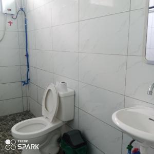 a bathroom with a toilet and a sink at Lucky777 Homestay in Mambajao
