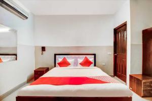 a bedroom with a large bed with red pillows at OYO Royal Inn Near Lotus Temple in New Delhi