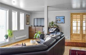 a living room with a leather couch and a television at Beautiful Home In Frresfjorden With 4 Bedrooms, Sauna And Wifi in Sørvåg