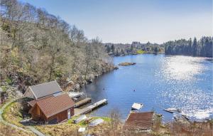 a view of a lake with a house and a dock at Beautiful Home In Frresfjorden With 4 Bedrooms, Sauna And Wifi in Sørvåg