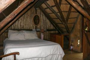 een slaapkamer met een groot bed op zolder bij Yellowwood Forest Eco Retreat in Morganʼs Bay