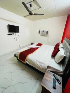 1 dormitorio con 1 cama y ventilador de techo en OYO Fortish Inn, en Indirapuram