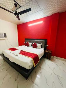 1 dormitorio con 1 cama con pared roja en OYO Fortish Inn, en Indirapuram