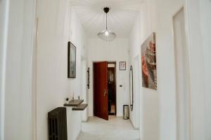 a hallway with white walls and a hallway with a suitcase at [Otranto in 10 min]-Free Parking in Maglie