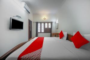 a bedroom with a large white bed with red pillows at OYO Home Tree Service Apartment Near Saravana Stores T Nagar in Chennai