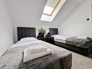 a bedroom with two beds and a skylight at Karczma Ostoya in Jasionka