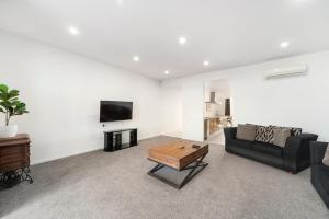 a living room with a couch and a coffee table at Lakeview Luxury - Taupo Holiday Apartment in Taupo