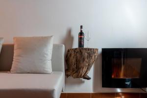un sofá con una botella de vino junto a la chimenea en Hamlet in the Countryside, en Fauglia