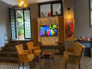 a living room with chairs and a tv on a wall at New Taksim Hotel in Istanbul