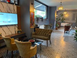 a living room with a couch and chairs and a flat screen tv at New Taksim Hotel in Istanbul +25 photos
