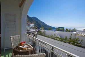 d'un balcon avec une table et des chaises et une vue sur l'océan. dans l'établissement Casa La Coccinella, à Praiano