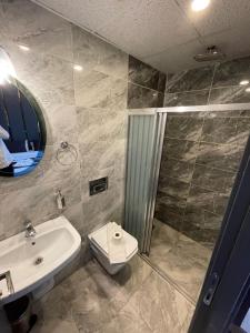 a bathroom with a toilet and a sink and a shower at New Taksim Hotel in Istanbul