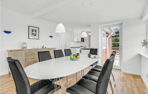 een keuken en eetkamer met een witte tafel en stoelen bij Beautiful Home In Prst With House Sea View in Stavreby