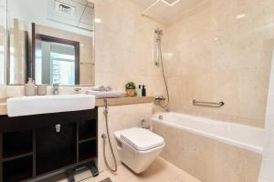een badkamer met een wastafel, een toilet en een bad bij Beautiful 1BR with sunset view Dubai Marina in Dubai