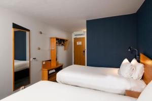 a hotel room with two beds and a mirror at Holiday Inn Express Newcastle City Centre by IHG in Newcastle upon Tyne