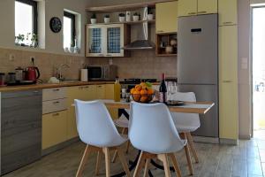 a kitchen with white chairs and a table with fruit on it at Piazza Masari in Haraki