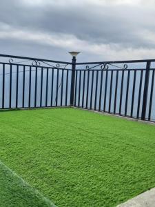 a black fence with green grass behind it at The Sangam Homestay in Kalimpong