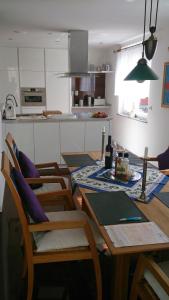 ユーバーリンゲンにあるDeluxe Apartmentのテーブル、椅子、テーブル席付きのキッチンが備わります。