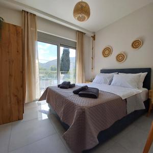 ein Schlafzimmer mit einem großen Bett und einem großen Fenster in der Unterkunft Dream Time Villa Vasiliki in Vasiliki