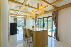 a kitchen with a island in a house at Neenlawat Riverside in Surat Thani
