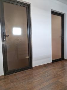 two sliding doors in a room with wood floors at Splendid Aparthotel in Năvodari