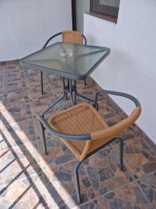 a glass table and a chair on a brick floor at Splendid Aparthotel in Năvodari