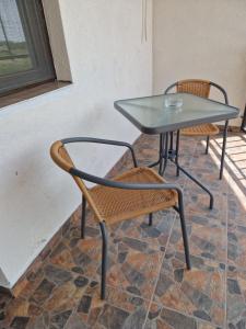 a glass table and two chairs and a glass table and chairs at Splendid Aparthotel in Năvodari